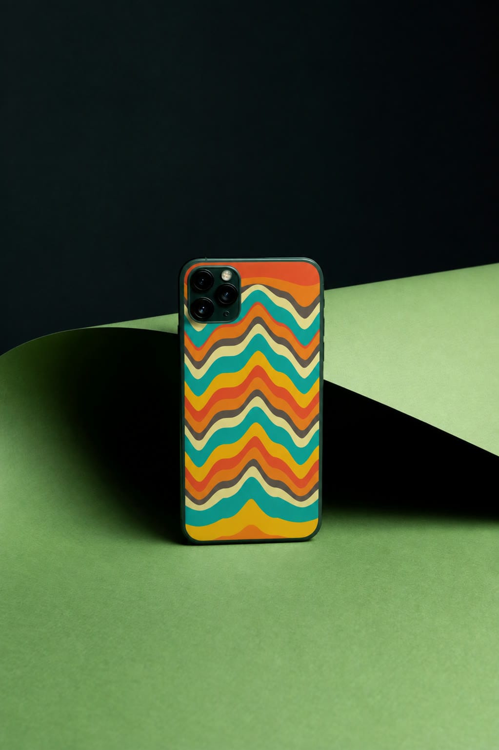 A chevron-printed Our Case phone case standing on a green paper backdrop