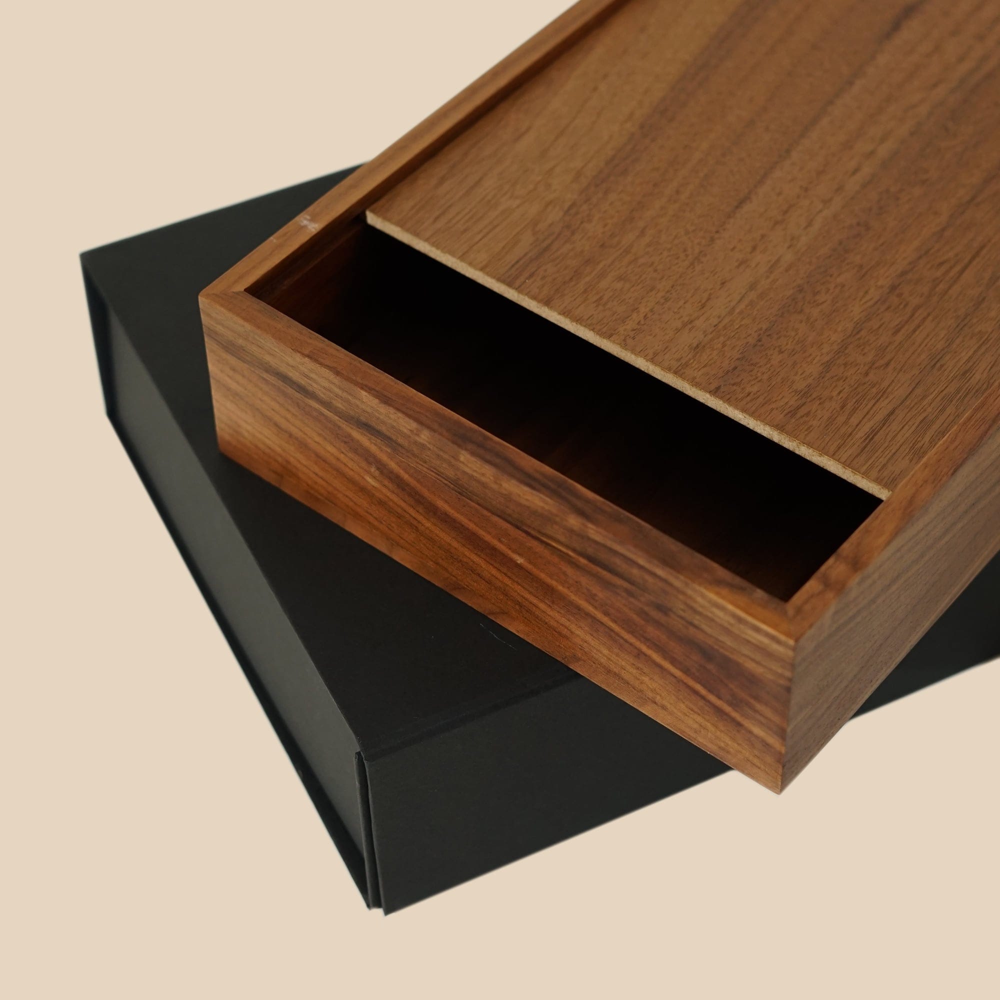 The walnut Memobox tray sliding out of its black sleeve
