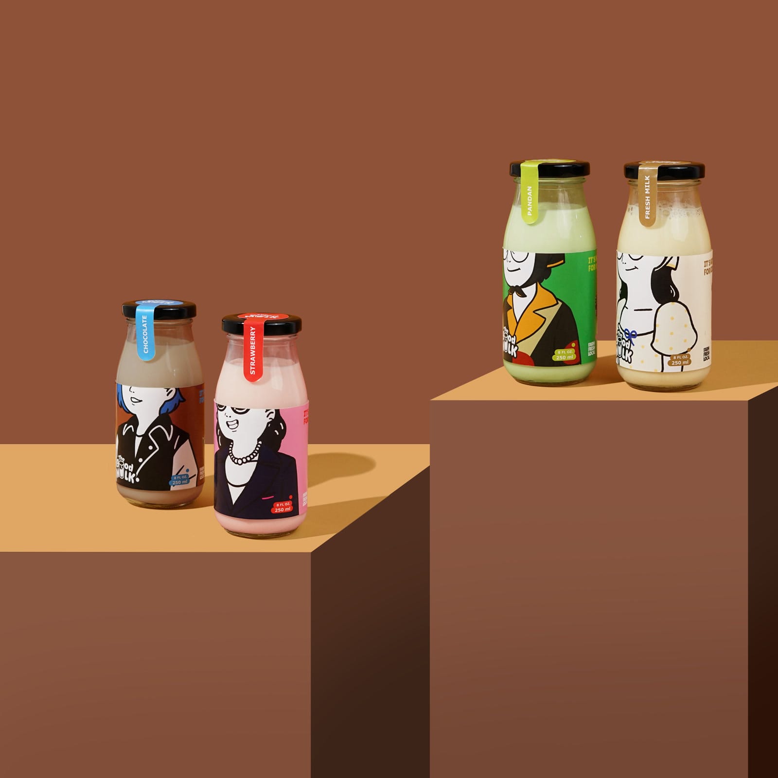 Four The Good Milk bottles arranged on tan pedestals against a brown backdrop